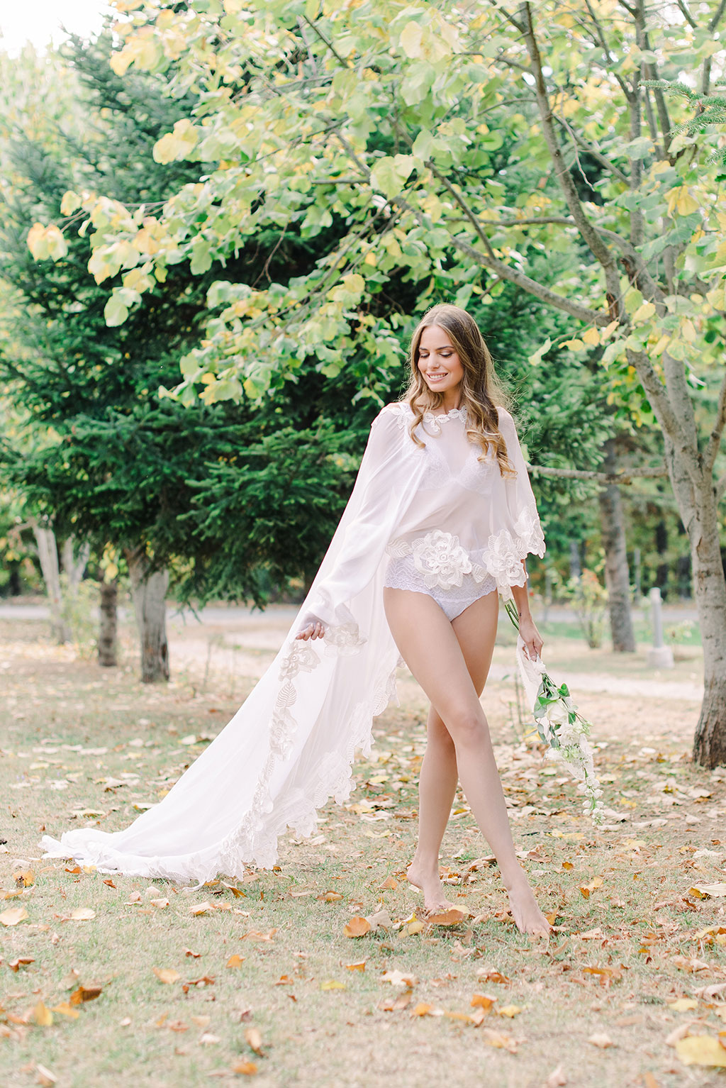 gorgeous bride at boudoir session walking in trees